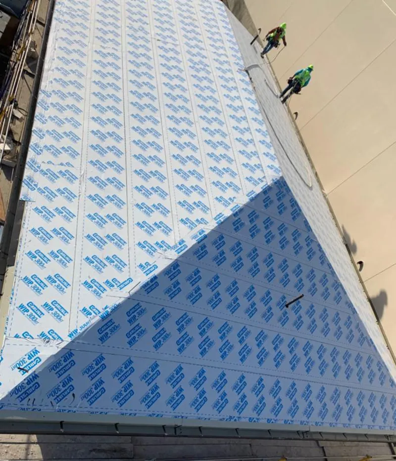 Professional roofers installing underlayment on a metal roof in Manchester